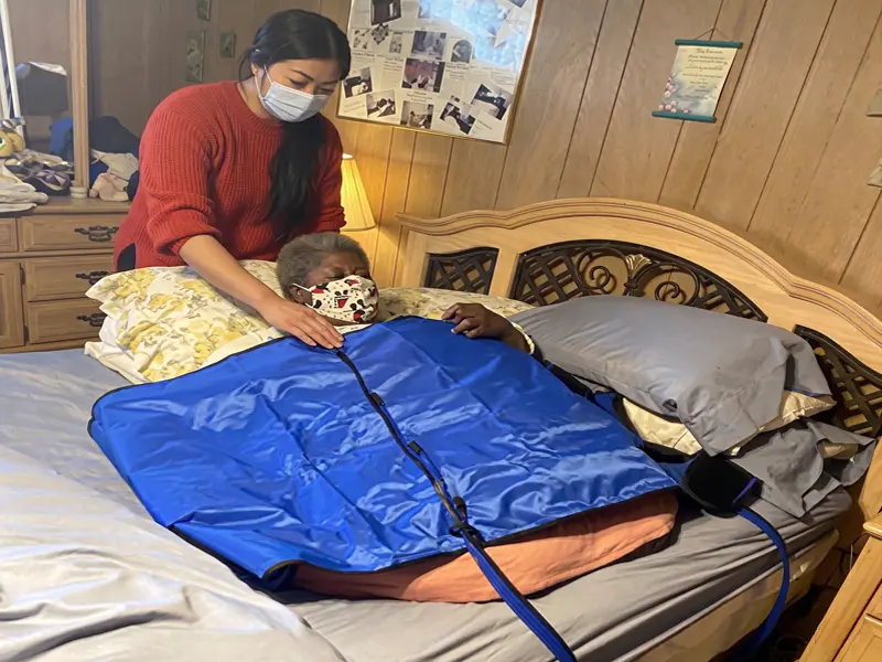 Healthcare professional assisting a patient with compression therapy treatment.